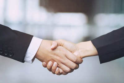 Closeup of a businessman hand shake businesswoman between two colleagues OK, succeed in business Holding hands.