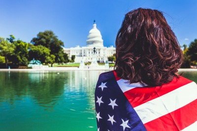 Woman and American Flag at Capitol Hill Building in Washington