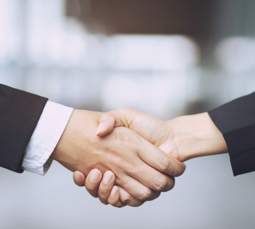 Closeup of a businessman hand shake businesswoman between two colleagues OK, succeed in business Holding hands.