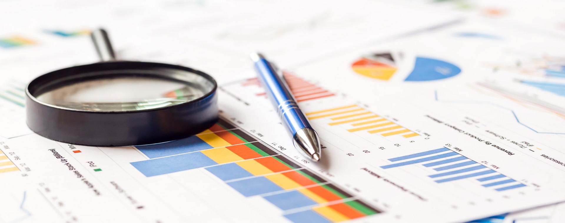 Magnifier and pen on charts graphs paper. Financial development. Banner