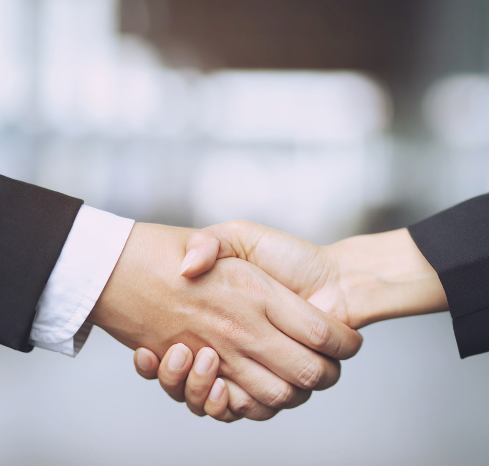 Closeup of a businessman hand shake businesswoman between two colleagues OK, succeed in business Holding hands.