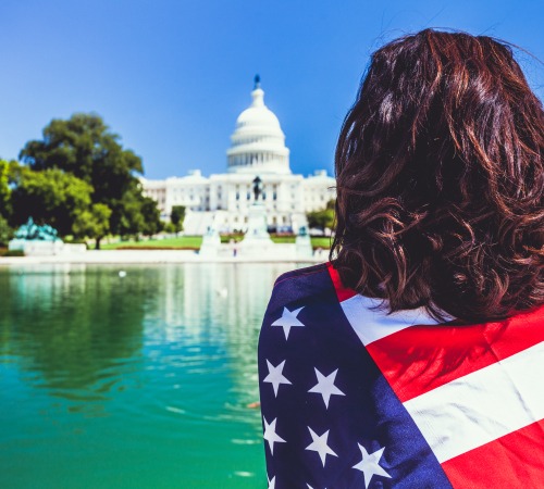 Woman and American Flag at Capitol Hill Building in Washington