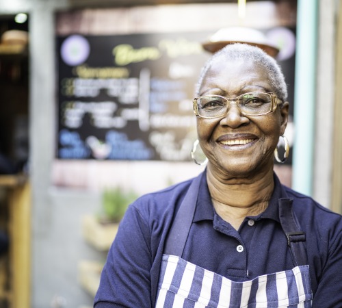 Senior woman working and standing in front of restaurant